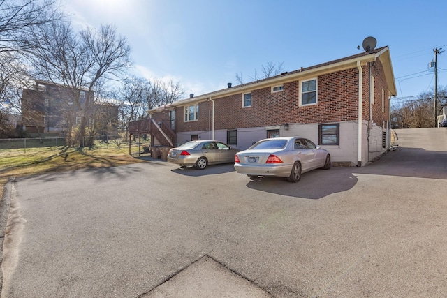 view of front of house featuring brick siding and fence