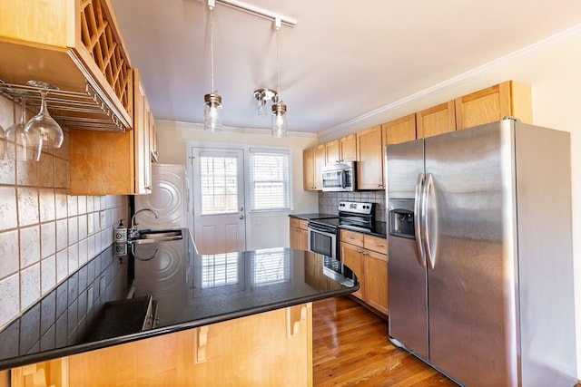 kitchen featuring stainless steel appliances, dark countertops, wood finished floors, and crown molding