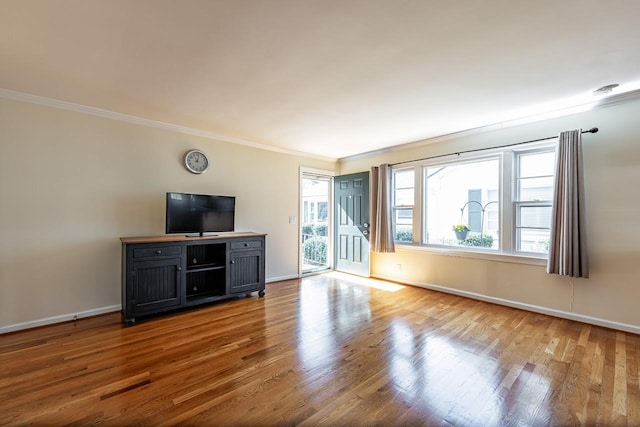 unfurnished living room with crown molding, baseboards, and wood finished floors