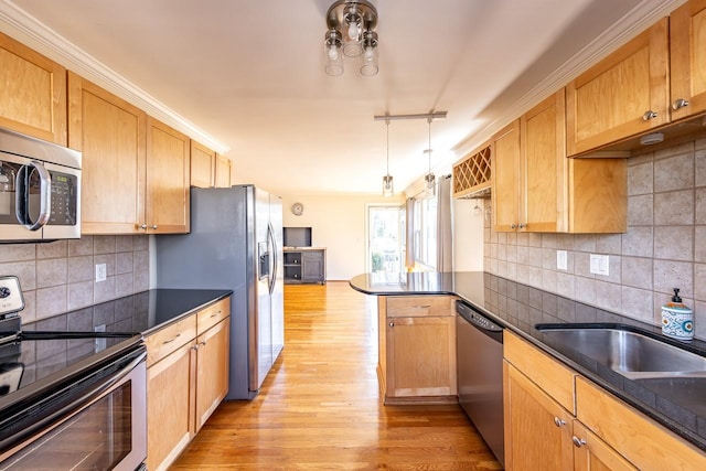 kitchen featuring a peninsula, appliances with stainless steel finishes, dark countertops, and light wood-style floors