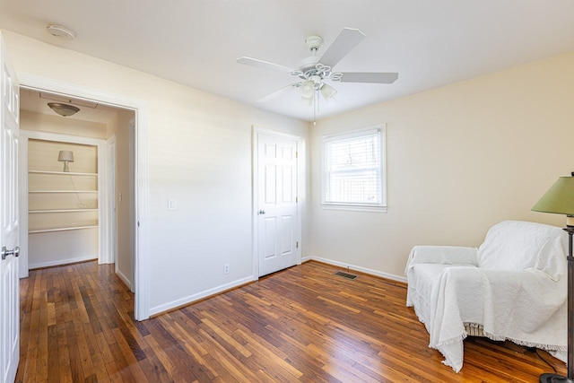 living area featuring hardwood / wood-style floors, visible vents, and baseboards