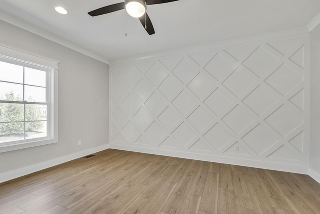 unfurnished room featuring an accent wall, light wood-type flooring, visible vents, and baseboards