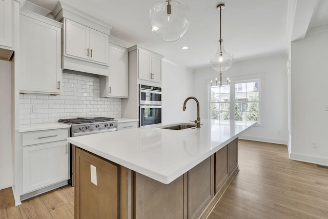 kitchen featuring light countertops, a sink, light wood finished floors, and decorative backsplash