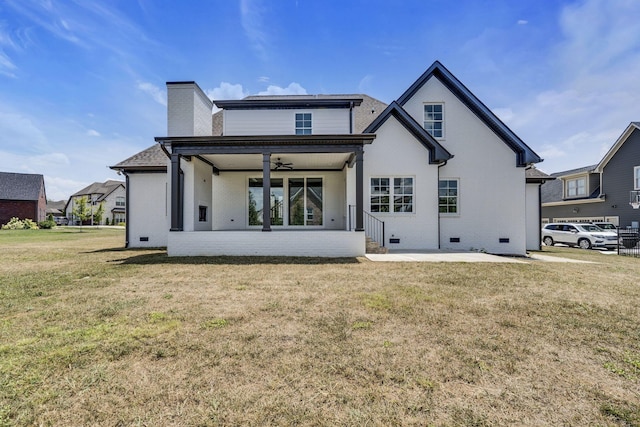 rear view of house with ceiling fan, brick siding, crawl space, and a lawn