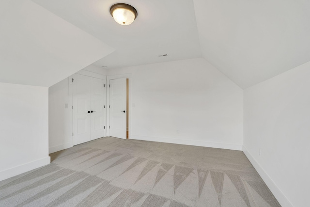 additional living space with vaulted ceiling, carpet, and baseboards