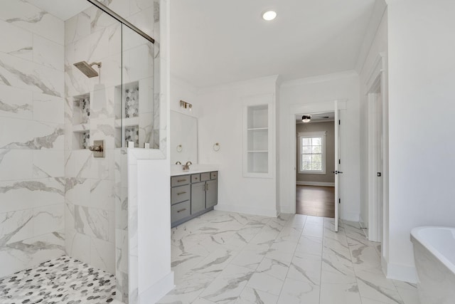 full bath featuring baseboards, ornamental molding, marble finish floor, a tile shower, and a freestanding tub