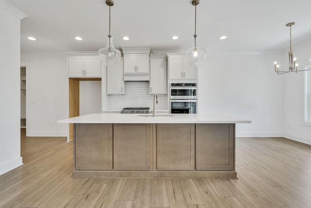 kitchen with tasteful backsplash, light countertops, light wood-style flooring, stainless steel double oven, and a sink