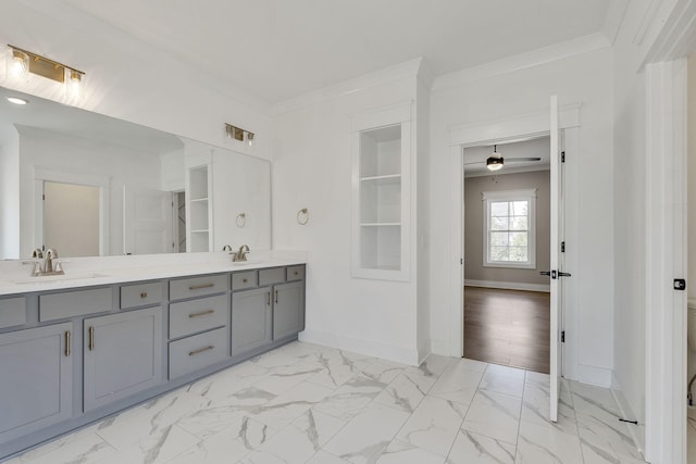 full bath featuring marble finish floor, ornamental molding, a sink, and baseboards