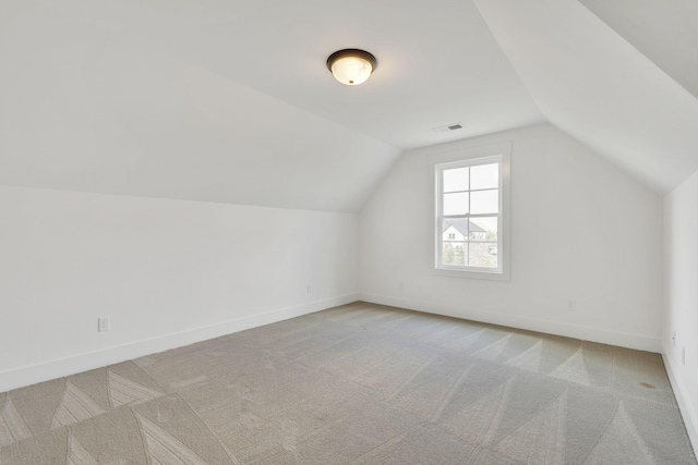 additional living space featuring lofted ceiling, baseboards, visible vents, and carpet flooring