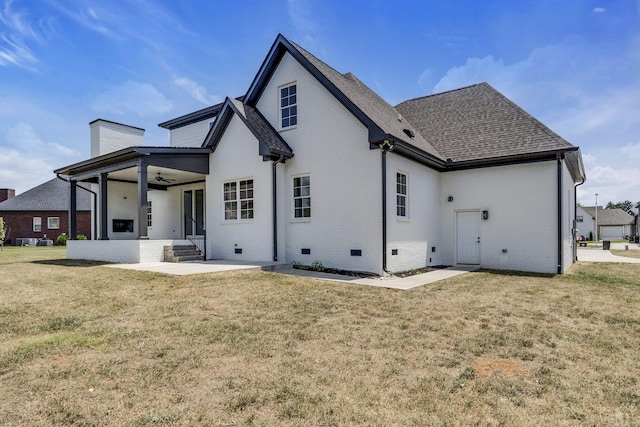 back of house with brick siding, a ceiling fan, a lawn, crawl space, and a chimney