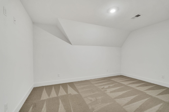 bonus room featuring lofted ceiling, carpet, visible vents, and baseboards