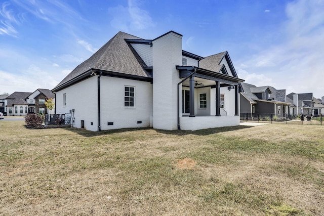 view of side of property featuring crawl space, a yard, fence, and brick siding