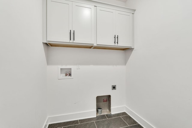 laundry area with cabinet space, baseboards, dark tile patterned flooring, washer hookup, and electric dryer hookup