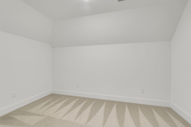 bonus room with light carpet, vaulted ceiling, and baseboards