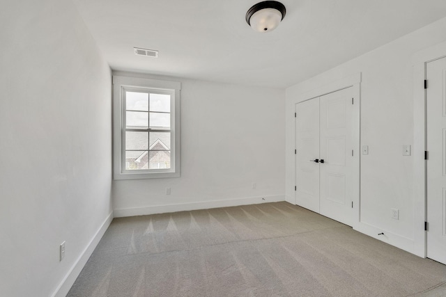 unfurnished bedroom featuring carpet floors, baseboards, and visible vents