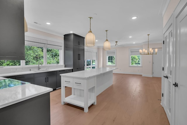 kitchen with a healthy amount of sunlight, light wood-type flooring, open shelves, and a sink