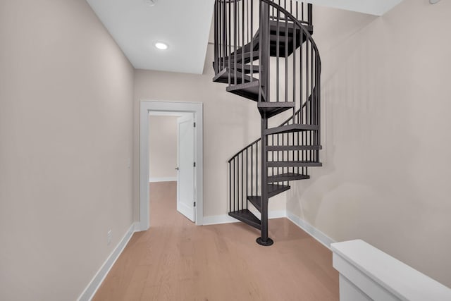 staircase with recessed lighting, wood finished floors, and baseboards