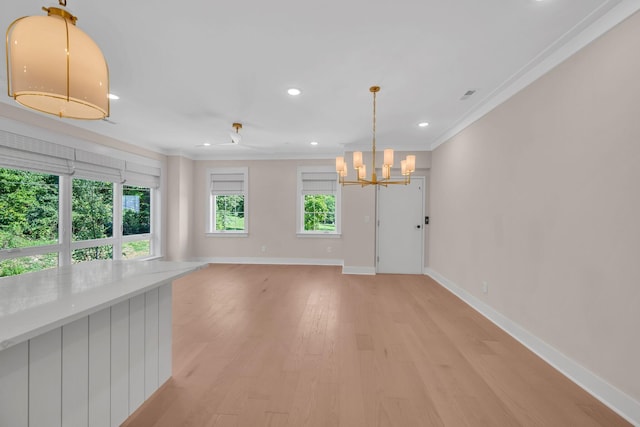 interior space with a healthy amount of sunlight, crown molding, light wood-style flooring, and baseboards