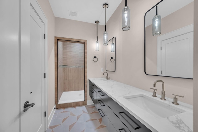 full bathroom featuring double vanity, a stall shower, a sink, and visible vents