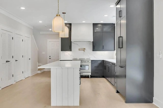 kitchen featuring a kitchen island, appliances with stainless steel finishes, gray cabinetry, premium range hood, and backsplash