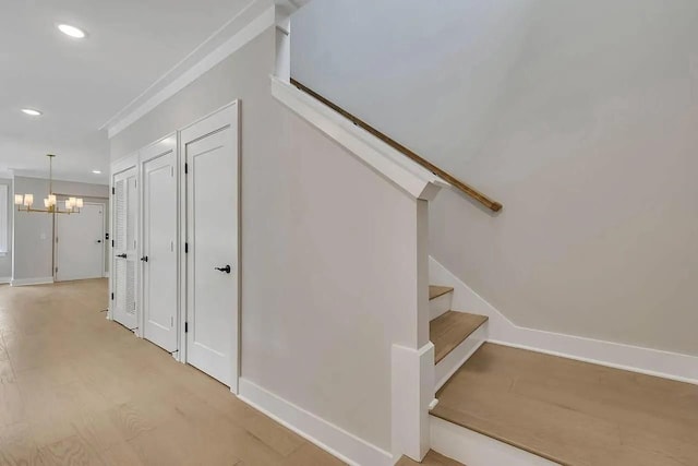 stairs featuring crown molding, recessed lighting, wood finished floors, a chandelier, and baseboards