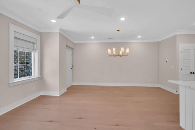 empty room featuring light wood-style floors, baseboards, and crown molding