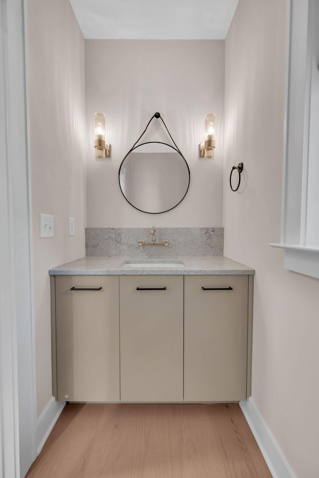 bathroom with wood finished floors, vanity, and baseboards