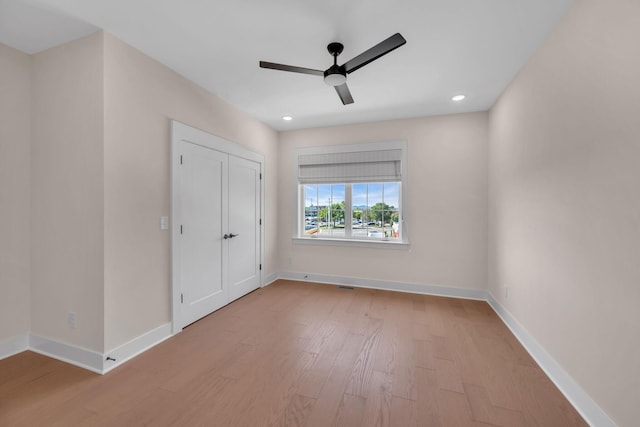 spare room with ceiling fan, wood finished floors, and baseboards