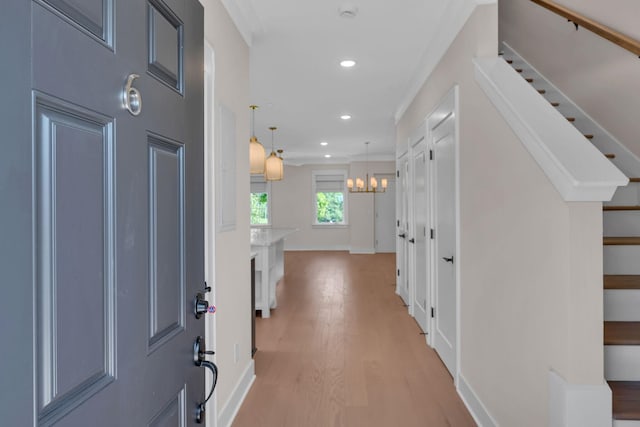 foyer entrance featuring recessed lighting, stairway, an inviting chandelier, light wood-style floors, and baseboards