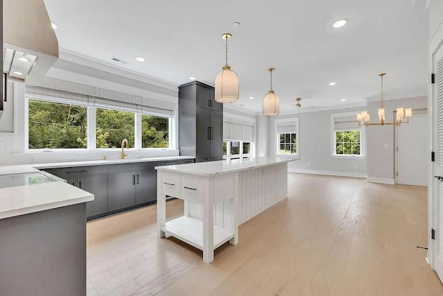 kitchen featuring recessed lighting, a kitchen island, visible vents, light countertops, and light wood finished floors