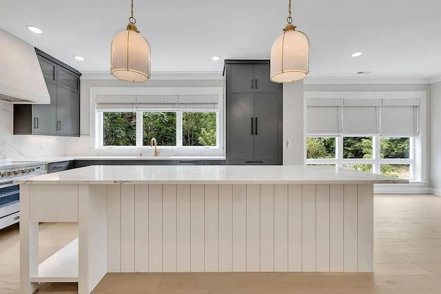 kitchen with decorative backsplash, decorative light fixtures, a kitchen island, and custom exhaust hood