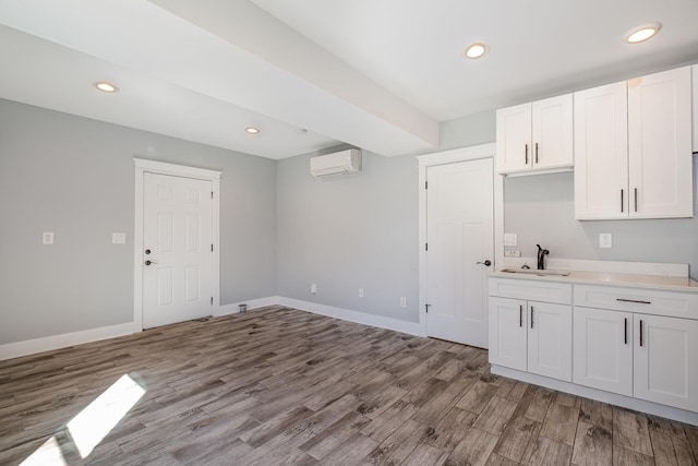 64 Harbor Pt, Lebanon, TN 37087 - kitchen with an AC wall unit, a sink, wood finished floors, light countertops, and white cabinets