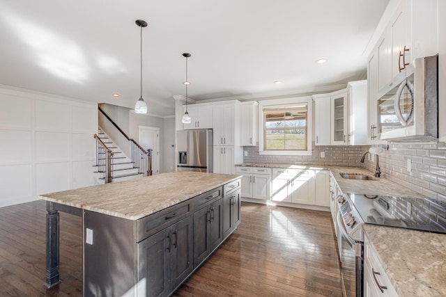 64 Harbor Pt, Lebanon, TN 37087 - kitchen with stainless steel appliances, a sink, white cabinets, dark wood-style floors, and ornamental molding