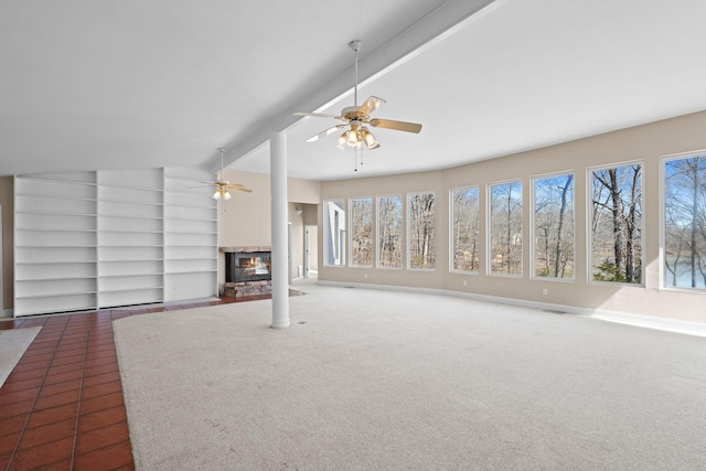 unfurnished living room with ceiling fan, lofted ceiling with beams, carpet floors, a fireplace, and baseboards