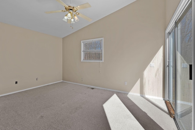 carpeted empty room with vaulted ceiling, visible vents, a ceiling fan, and baseboards