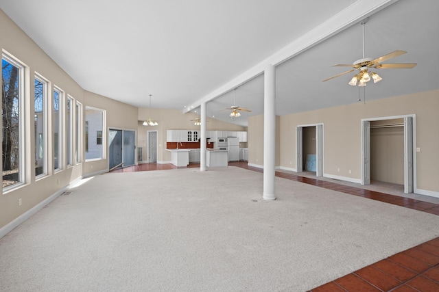 interior space with vaulted ceiling with beams, carpet, baseboards, and ceiling fan with notable chandelier