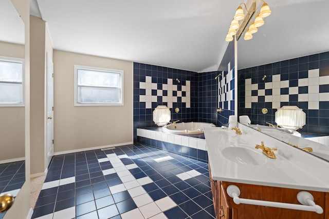 bathroom with a relaxing tiled tub, baseboards, tile patterned floors, vanity, and tile walls