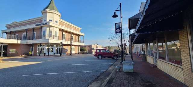 view of road with curbs, sidewalks, and street lights