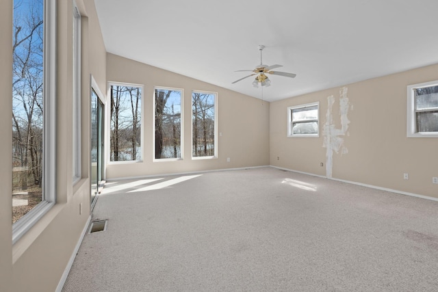 unfurnished room with carpet, visible vents, a ceiling fan, vaulted ceiling, and baseboards