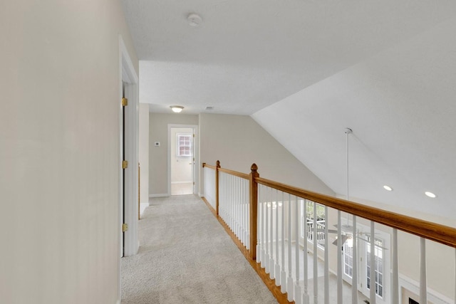 corridor with lofted ceiling, carpet floors, and baseboards