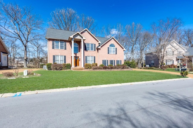 view of front of property with a front yard and brick siding