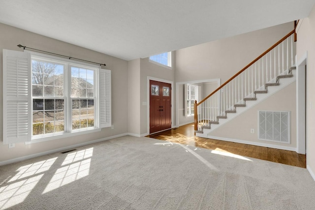 entryway with a healthy amount of sunlight, stairs, and visible vents