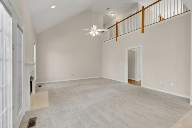 unfurnished living room featuring visible vents, baseboards, a fireplace with flush hearth, carpet, and high vaulted ceiling