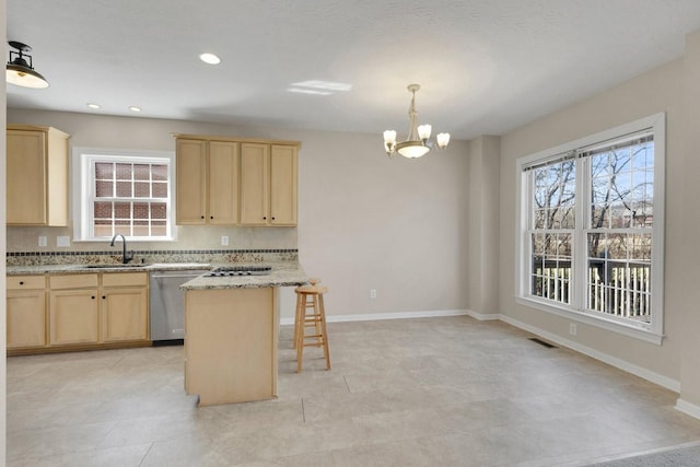 kitchen with visible vents, light brown cabinets, a sink, dishwasher, and a kitchen breakfast bar