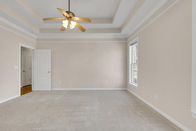 unfurnished room featuring carpet, a raised ceiling, and baseboards