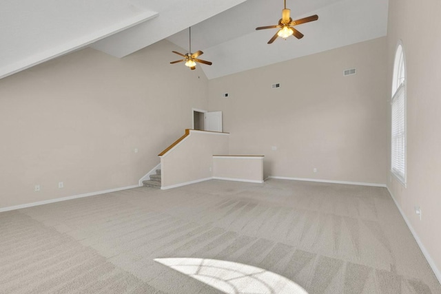 unfurnished living room with visible vents, baseboards, light colored carpet, stairway, and high vaulted ceiling