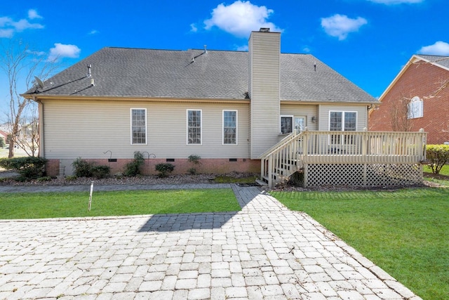 back of property featuring roof with shingles, a chimney, a lawn, crawl space, and a wooden deck