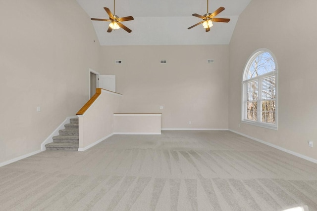 unfurnished living room featuring high vaulted ceiling, carpet, stairway, and baseboards