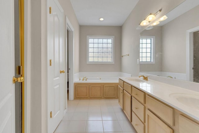 bathroom featuring tile patterned flooring, double vanity, a sink, and a bath