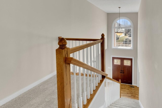 stairway with carpet floors, visible vents, and baseboards